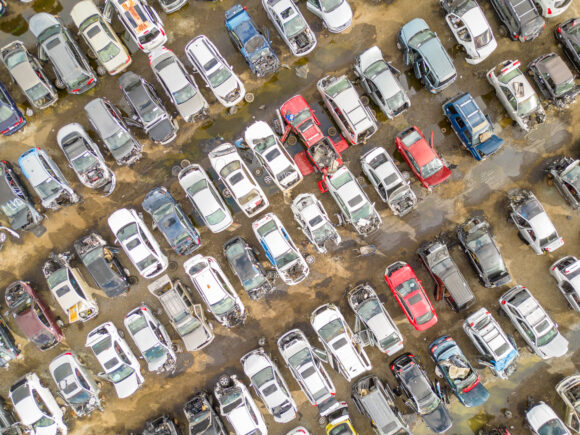 Aerial overhead shot of wrecked damaged cars at a automotive junk yard